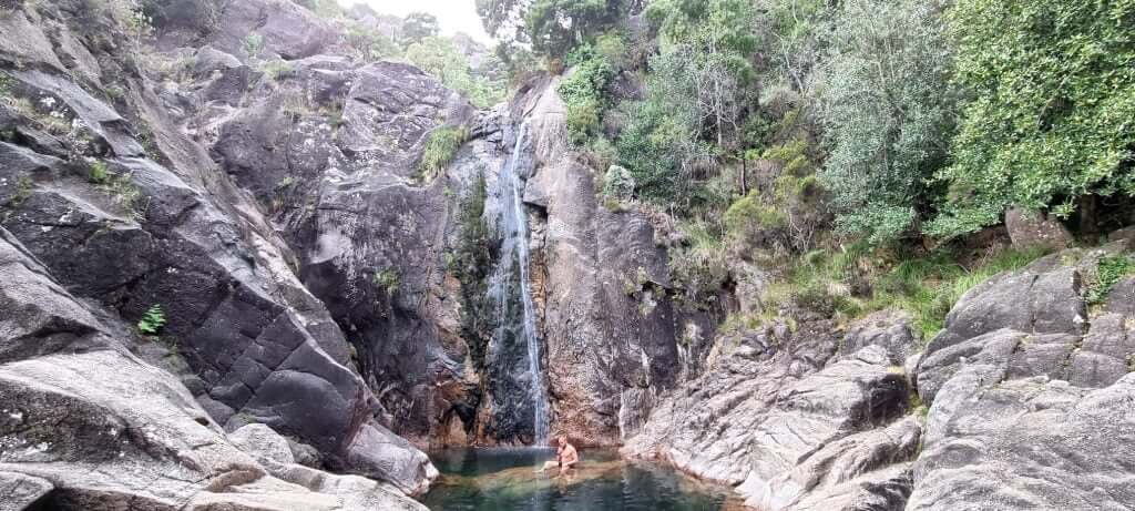 Tall Cascata do Arado waterfall with rocky cliffs