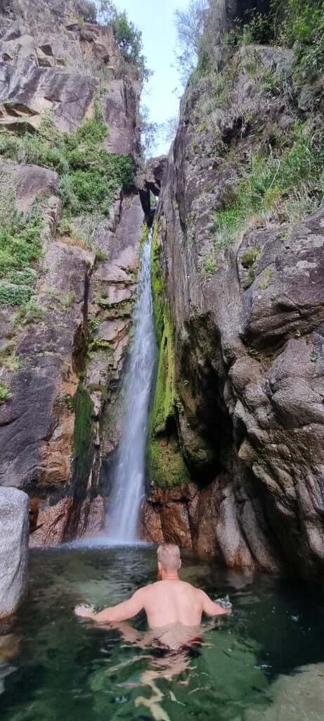 Cascata de Picaes waterfall between tall rock walls